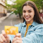 You Are Ready To Move On From Your No-Fee Credit Card, What's Next? 17 image of young woman smiling while showing credit 2023 11 27 05 32 00 utc min